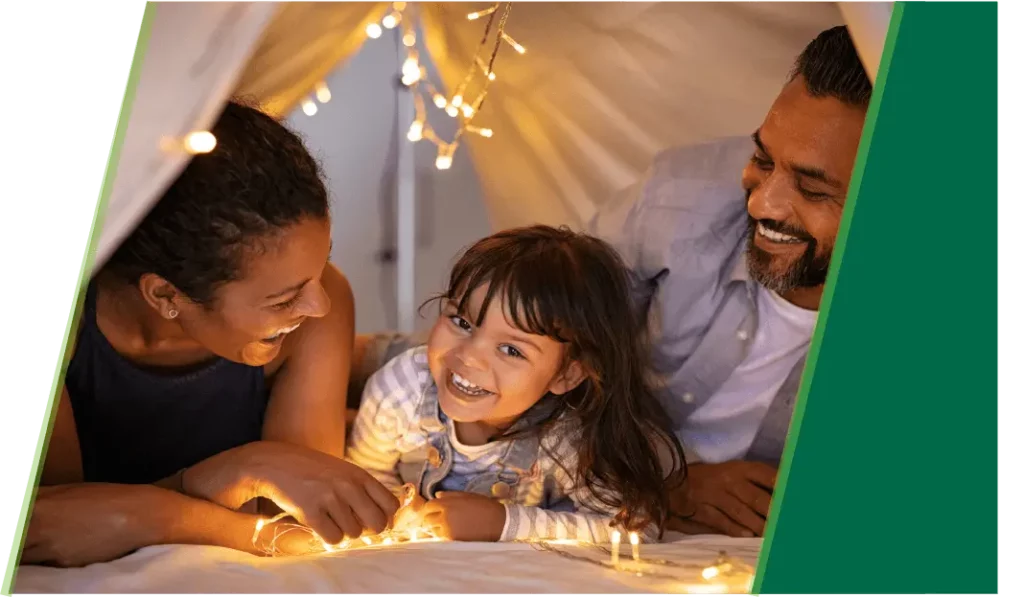 Mother and father in homemade tent with daughter